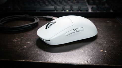 Ratón inalámbrico Logitech G Pro X Superlight 2 SE en color blanco sobre un escritorio oscuro junto a su cable de carga.