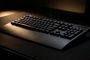 Teclado Logitech G213 Prodigy con retroiluminación azul y reposamanos integrado sobre una alfombrilla oscura.