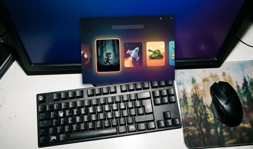 Interfaz de la nueva aplicación de Epic Games superpuesta sobre un escritorio con teclado mecánico y ratón inalámbrico.