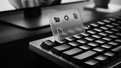 Primer plano de un teclado mecánico con una tecla de búsqueda iluminada y una interfaz translúcida que muestra iconos de archivos y configuración.