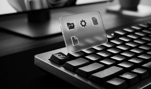 Primer plano de un teclado mecánico con una tecla de búsqueda iluminada y una interfaz translúcida que muestra iconos de archivos y configuración.