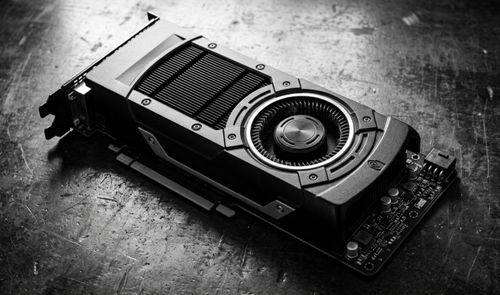 Primer plano en blanco y negro de una tarjeta gráfica NVIDIA GeForce GTX con ventilador de tipo turbina sobre una superficie metálica desgastada.