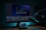 Interfaz de OBS Studio abierta en un monitor junto a un micrófono profesional, una consola Stream Deck y un PC de sobremesa.