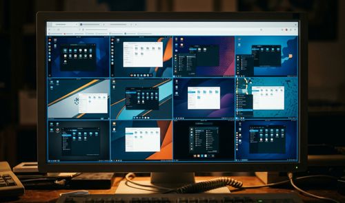 Monitor de ordenador que muestra una cuadrícula en el navegador con múltiples interfaces de distribuciones Linux funcionando en paralelo.