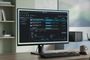 Interfaz del software qBittorrent 5.3 mostrada en un monitor de escritorio con varios archivos en descarga y gráficas de tráfico.