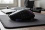Vista lateral de un ratón Razer Naga V2 HyperSpeed sobre una alfombrilla negra, mostrando su panel lateral con múltiples botones programables.