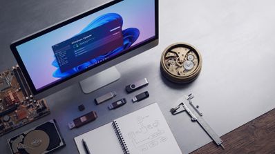Escritorio con monitor que muestra la ventana de Windows Update junto a componentes de hardware, un reloj de engranajes y herramientas de medición.