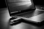 Memoria USB conectada al puerto lateral de un ordenador portátil sobre una mesa oscura.