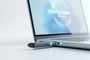 Memoria USB conectada al puerto lateral de un ordenador portátil que muestra una barra de carga en pantalla.